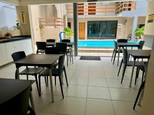 a restaurant with tables and chairs and a swimming pool at Hotel Pousada Alagoana in Maceió