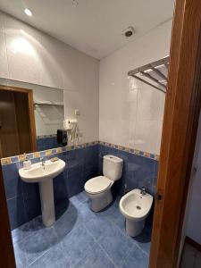 ein Badezimmer mit zwei Waschbecken, einem WC und einem Spiegel in der Unterkunft P Residencia PIVIDAL in Picaraña