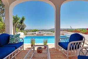 un patio con sillas azules y una piscina en VIVENDA ALGARVIA, en Bordeira