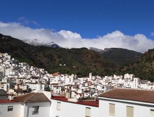 een groep witte gebouwen met bergen op de achtergrond bij Apartamento El Almencino in Tolox
