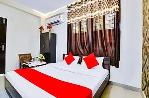 a bedroom with a large bed with red pillows at Hotel In Lajpat Nagar in New Delhi