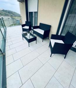 a patio with chairs and tables on a balcony at Casa Adele in Salerno