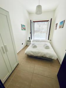 a white bedroom with a bed and a window at Casa Adele in Salerno