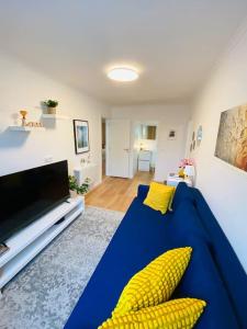 a living room with a blue couch and yellow pillows at Modern 3 bedroom Flat in Lisbon in Lisbon