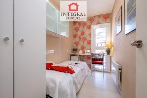Habitación pequeña con cama con almohadas rojas en AquaVista Apartament Palamós, en Palamós