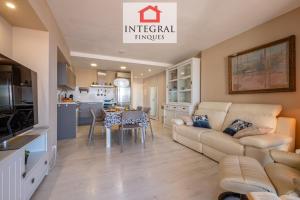 Una sala de estar y una cocina con un sofá y una mesa. en AquaVista Apartament Palamós, en Palamós