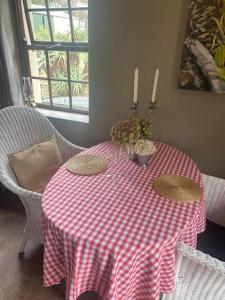 una mesa con un mantel a cuadros rojo y blanco en Staandakkie Guest Cottage, en Bredasdorp