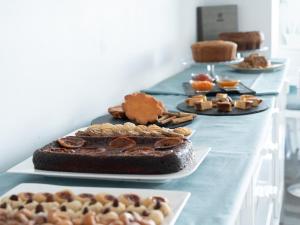 a long table with different types of cakes and pastries at Balneario Pozo de la Salud in Sabinosa