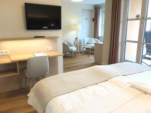 een hotelkamer met een bed, een bureau en een televisie bij Hotel Zur Traube in Ürzig