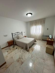 P Residencia PIVIDAL في Picaraña: غرفة نوم بسرير وأرضية رخام كبيرة