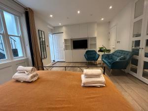 1 dormitorio con 1 cama con 2 toallas en Pop Art Luxury Room Marylebone en Londres