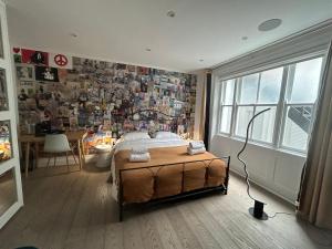 Schlafzimmer mit einem Bett und einer Wand mit Fotos in der Unterkunft Pop Art Luxury Room Marylebone in London