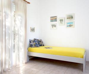 a bedroom with a yellow bed in a white room at Victoria Studios & Apartments in Skala Eresou