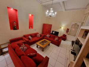 a living room with red couches and a table at Hostel Estoril in Buenos Aires