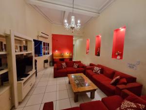 a living room with red couches and a coffee table at Hostel Estoril in Buenos Aires