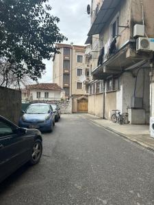 two cars parked on a street next to a building at APARTMENT Toxhi in Shkodër