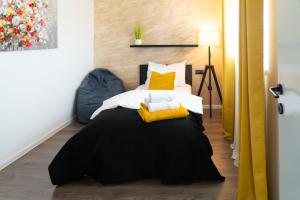 ein Schlafzimmer mit einem schwarzen Bett und gelben Kissen in der Unterkunft B&B Spavalica in Vir