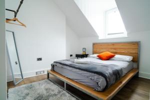 Schlafzimmer mit einem Bett mit einem Kopfteil aus Holz in der Unterkunft Plymouth Hoe - Beautiful 5 Bedroom Victorian House - Central Location in Plymouth