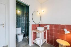 uma casa de banho com um WC e um espelho. em Madrid Live Coworking - SELF SERVICE - em Madri