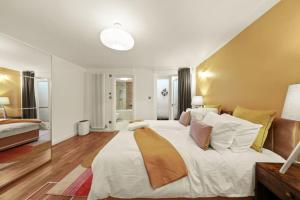 a large bedroom with a large white bed with pillows at Stylish Apartment in Euston and near Camden with Private Roof Terrace in London