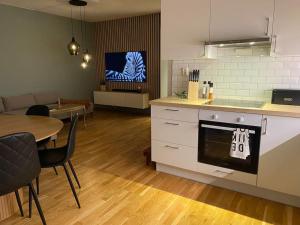 a kitchen and dining room with a table and a stove at Strøken leilighet inkl parkeringskjeller. in Trondheim