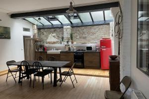 een keuken met een tafel en stoelen en een rode koelkast bij Spacious house near Honfleur harbour in Honfleur