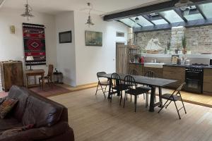 een woonkamer met een tafel en stoelen en een keuken bij Spacious house near Honfleur harbour in Honfleur