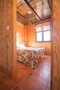 Un dormitorio con una cama en una habitación de madera. en Casa Rural Tio Maceta, en Bullas