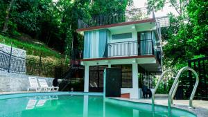 een huis met een zwembad en een gebouw bij Escape Resorts Vayalada in Kozhikode