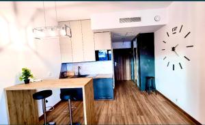 a kitchen with a counter and a clock on the wall at Hanza Tower De Lux Green in Szczecin