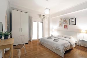 a white bedroom with a bed and a desk at Central Kolonaki flat B - Greecing in Athens