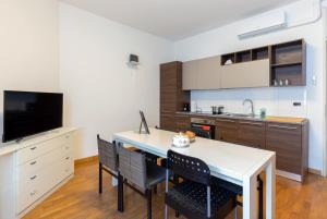 una cucina con tavolo, sedie e TV di Apartments by the lake a Como