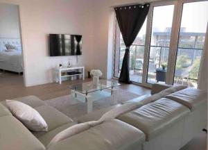 een woonkamer met een witte bank en een glazen tafel bij Luxury apartment with stunning view - Guillemins in Brussel