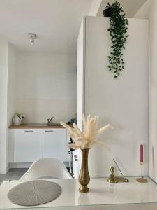 een witte keuken met een vaas op een tafel bij Luxury apartment with stunning view - Guillemins in Brussel