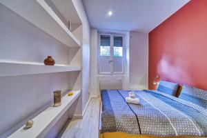 グルノーブルにあるLe centre ville 2の青いベッドと窓付きの小さなベッドルームが備わります。