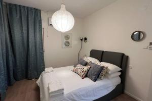 a bedroom with a bed with pillows and a lamp at Gabriel Apartments - JAFFA Street 214 Suits + Balcony in Bet HaKerem