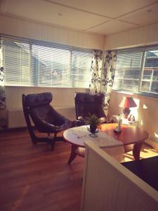 sala de estar con 2 sillas y mesa en Vertshuset Fannarheimr, en Orkanger