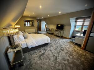 a bedroom with a large bed and a bathroom at The Cottage @ The Vu in Torphichen