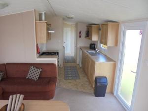 a living room with a couch and a kitchen at Seaview Ingoldmells Bromley 10 Berth 4 Bedrooms FREE WIFI in Ingoldmells