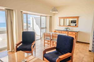 Apartment Sea view 1B في بورتيماو: غرفة معيشة مع طاولة وكراسي والمحيط