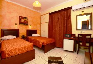 Un pat sau paturi într-o cameră la Pergamos Hotel