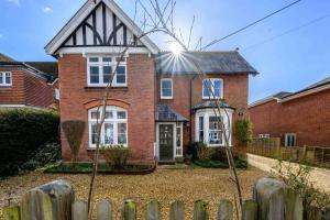 a brick house with a fence in front of it at Fern Villa in Lymington