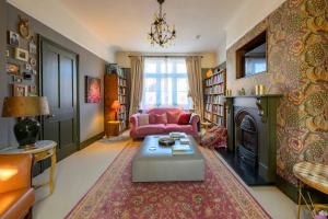 a living room with a pink couch and a fireplace at Fern Villa in Lymington