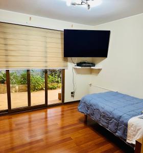 a bedroom with a bed and a flat screen tv at Descanso urbano in Santiago