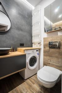 a bathroom with a washing machine and a sink at VipWarsawApartments Cytryn Mennica Residence in Warsaw