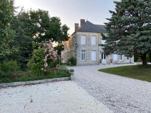 uma casa com uma entrada de cascalho em frente em Domaine de la Perthuiserie em Saint-Porchaire