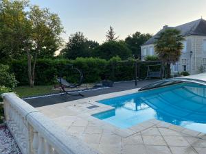 uma piscina num quintal ao lado de uma cerca em Domaine de la Perthuiserie em Saint-Porchaire