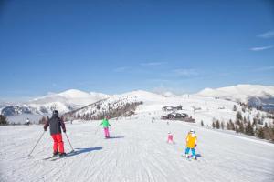 un grupo de personas esquiando por una pista cubierta de nieve en Ferienwohnung Earthloft, en Bad Kleinkirchheim