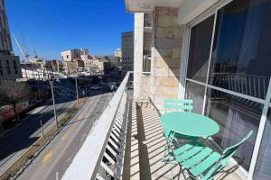 a balcony with a table and chairs on a building at Gabriel Apartments - JAFFA Street 214 Suits + Balcony in Bet HaKerem