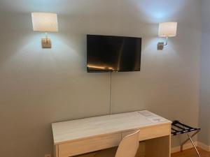 アスケカ・デ・エナレスにあるミラルカンポのデスク、壁掛けテレビが備わる客室です。